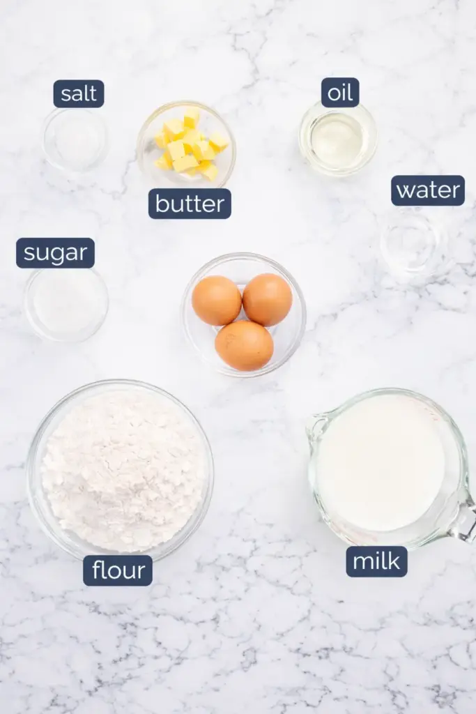 Crêpe ingredients laid out including flour, milk, eggs, sugar, and butter