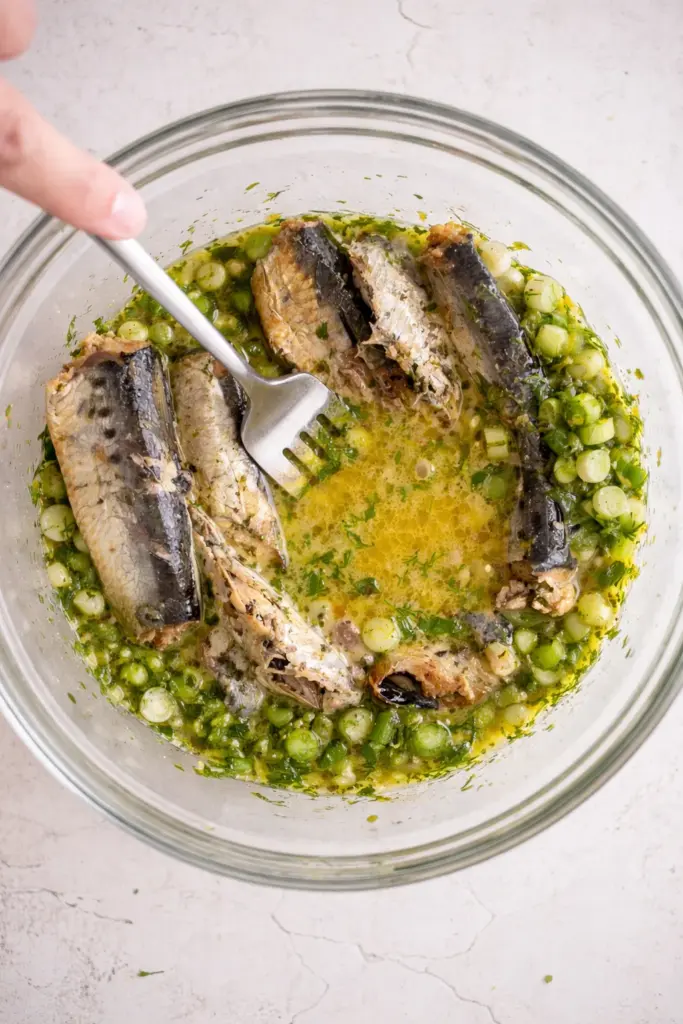 Flaking sardine fillets gently with fork