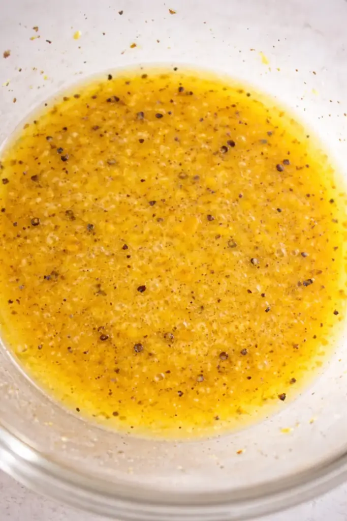 Whisking dressing until smooth emulsion forms