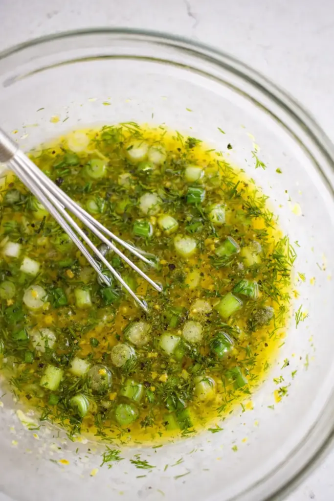 Adding chopped green onions, dill and capers to dressing