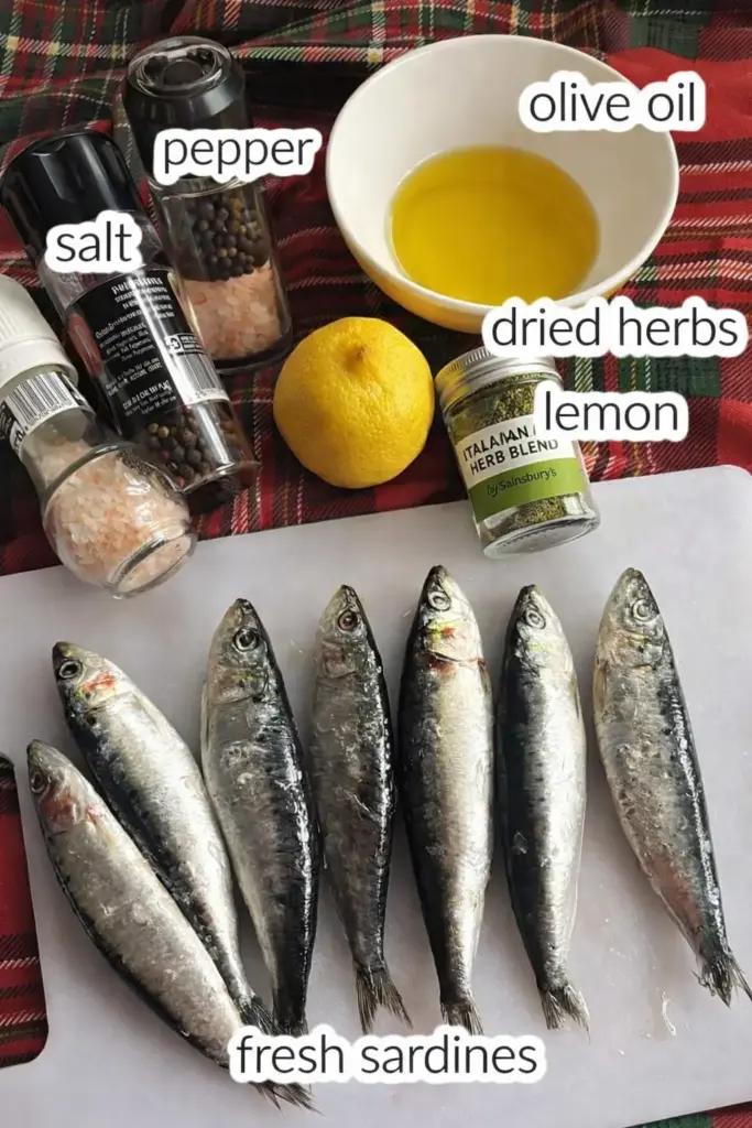 Fresh sardines seasoned with lemon, olive oil and herbs on baking sheet
