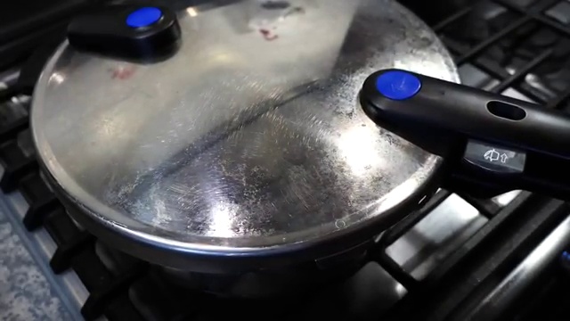Back of a spoon gently mashing some cooked kidney beans to naturally thicken gravy