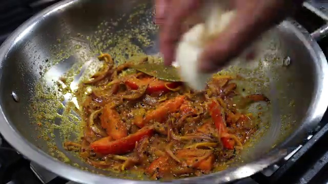Dried bay leaf and Bengali panch phoron five-spice crackling in hot oil in a pot