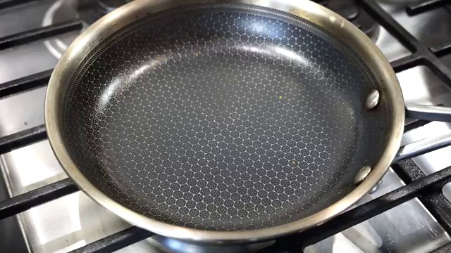 Ladle of chickpea batter added to hot pan and spread gently into a round pancake