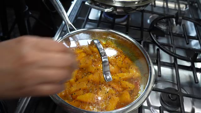 Chili powder sprinkled over softening pumpkin cubes and gently tossed