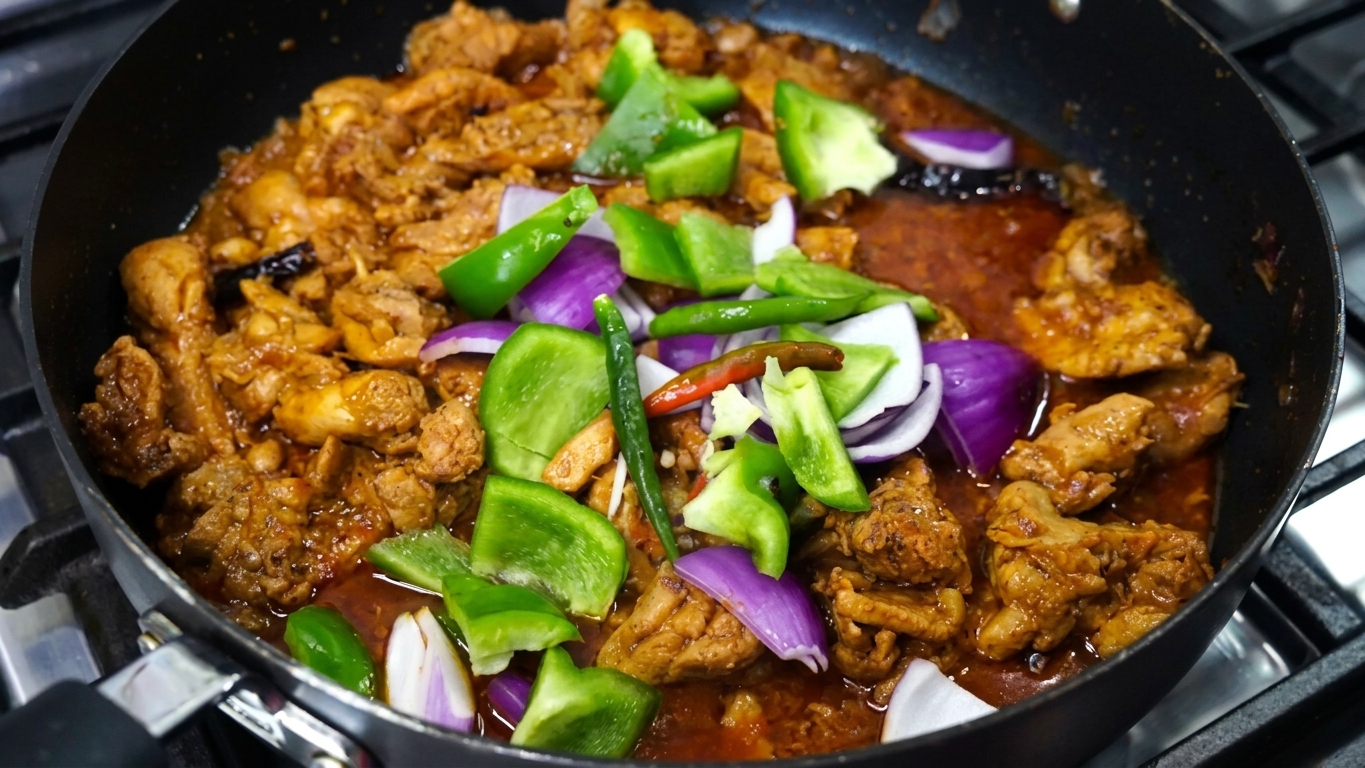 Chunky onion petals and vibrant green bell pepper cubes added to the skillet with chicken