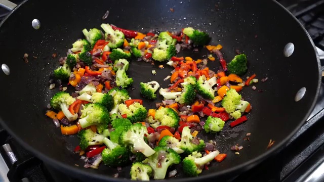 Fresh green chili pepper halved and added to the colorful vegetable stir-fry