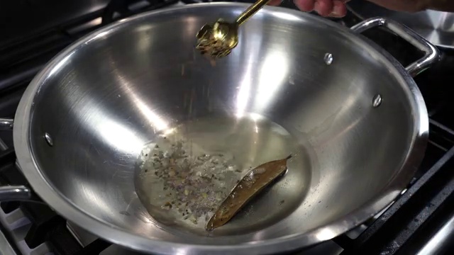 Fresh garlic cloves, ginger slices, whole cumin seeds, and black peppercorns in blender jar