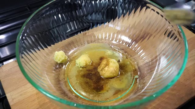 Freshly grated garlic and ginger added into the bowl with cooking oil