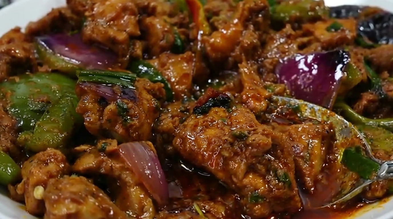Bite-sized chicken pieces in a bowl topped with sweet paprika, black pepper, ginger, garlic, soy sauce, and vinegar