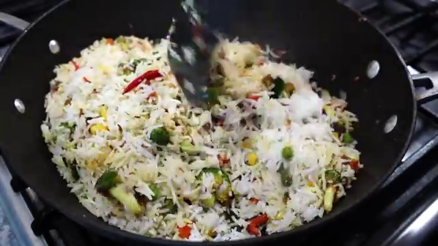Two tablespoons of water splashed into the hot pan around the masala rice