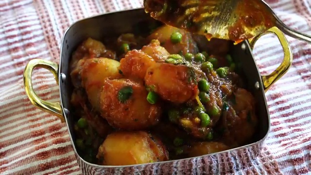 Homestyle Aloo Dum potato curry served hot with warm roti and fresh coriander