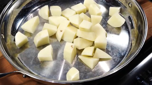 Marinated chicken thighs and drumsticks arranged in a single layer over seasoned potatoes and onions