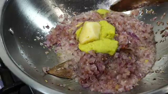 Dry bay leaf and cinnamon stick sizzling in aromatic hot oil and ghee