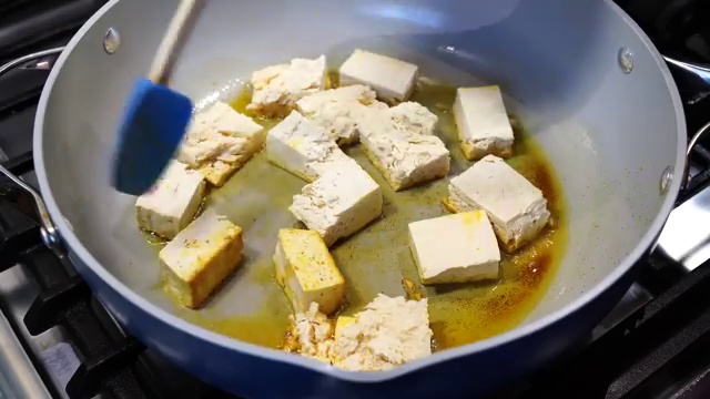 Dried bay leaf and whole cumin seeds sizzling in melted ghee and oil
