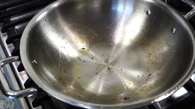 Dry bay leaf and whole dried red chilies sizzling gently in hot oil