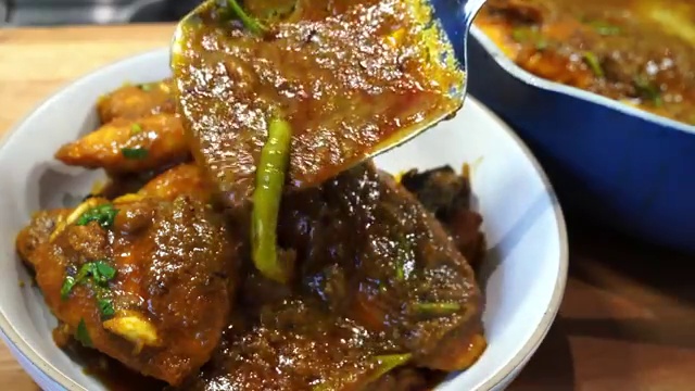 Bengali Macher Jhal served hot in a bowl with fluffy steamed white rice