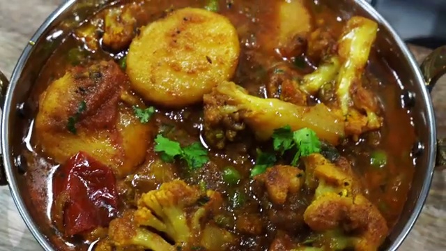Bengali aloo fulkopir tarkari served hot in a traditional bowl with steamed basmati rice