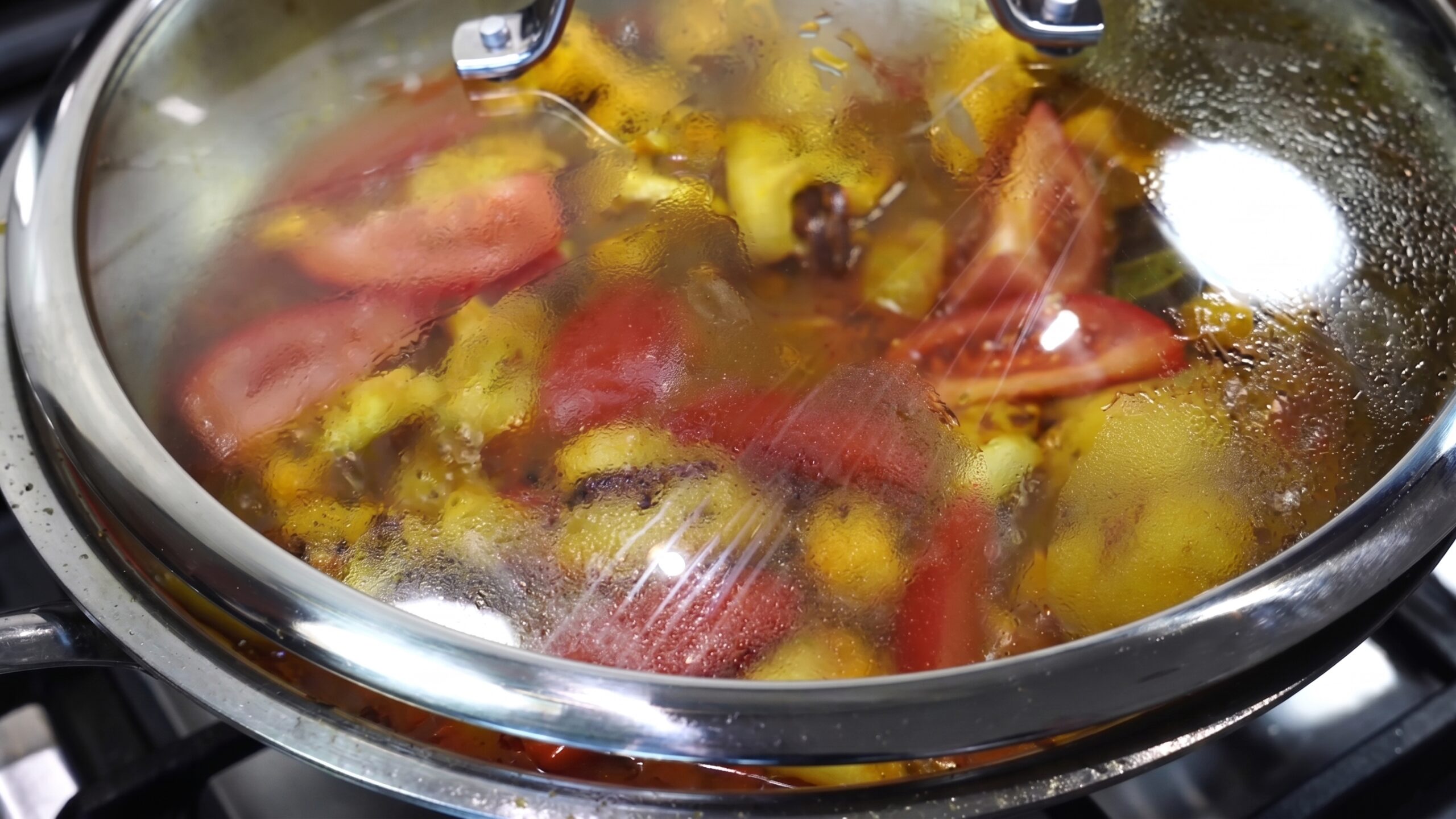 Bengali cauliflower and potato curry simmering gently in a partially covered pan