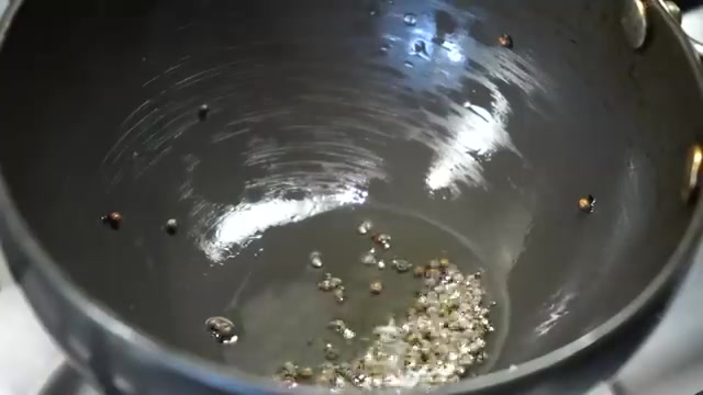 Black mustard seeds crackling in hot oil for the chutney tempering