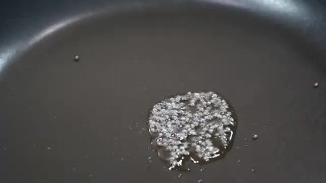 Black mustard seeds crackling in hot oil in a pan