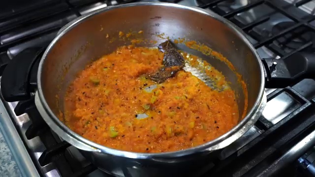 Bone-in chicken pieces added to the pot and stirred to coat in the aromatic spices