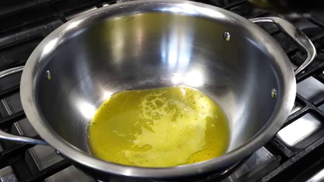 Glossy butter chicken tomato gravy simmering gently and deepening in red-orange color