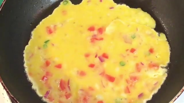 Buttered bread slice placed on top of the still-runny omelette in the frying pan