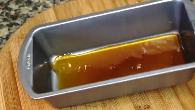 Buttered steaming container coated with an even layer of golden caramel
