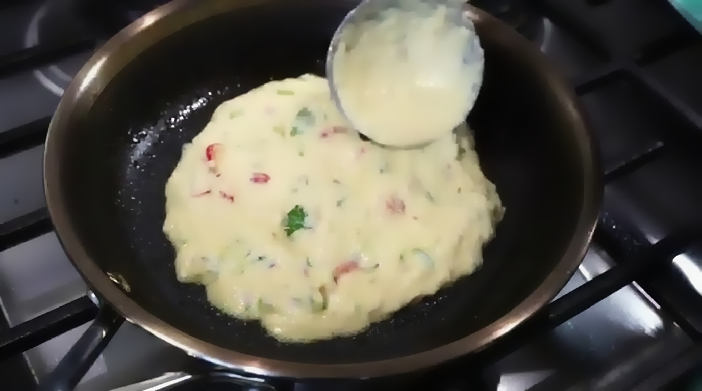 Skillet covered with lid to steam the chickpea chilla on low heat until surface sets