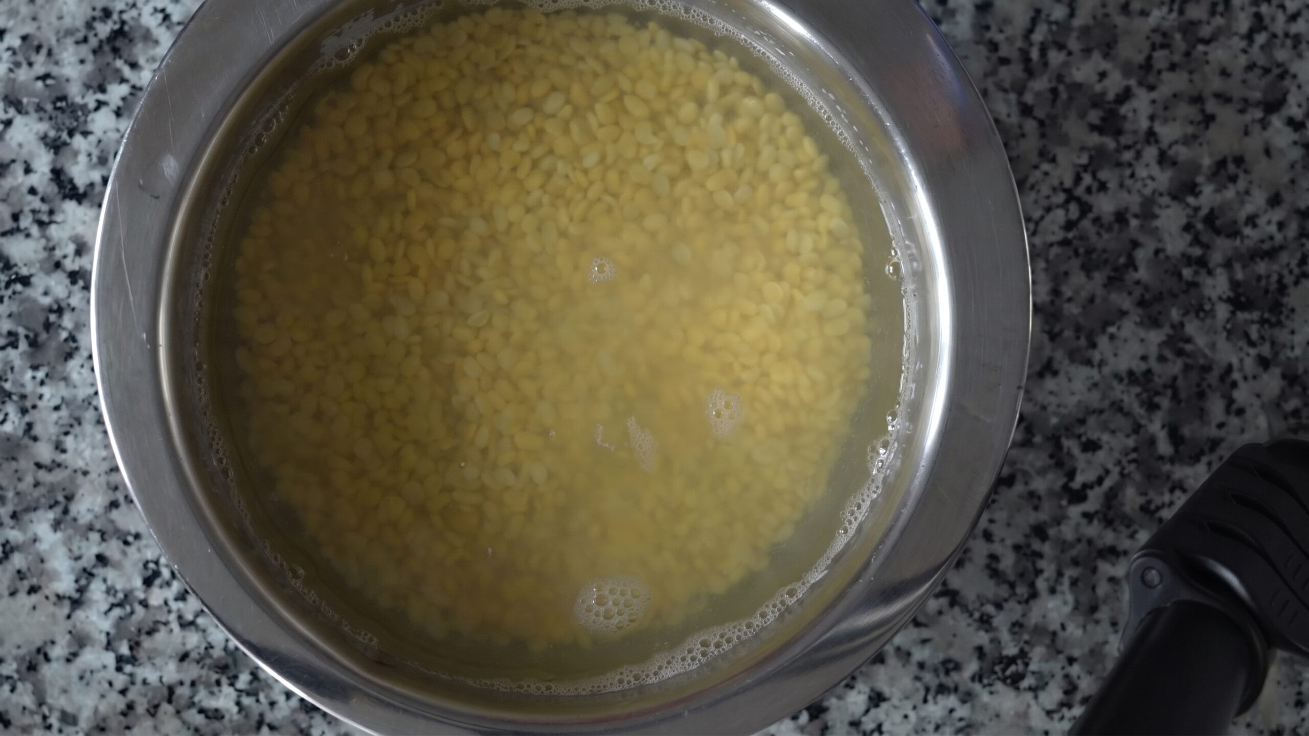 Yellow split moong dal soaking in water in a bowl