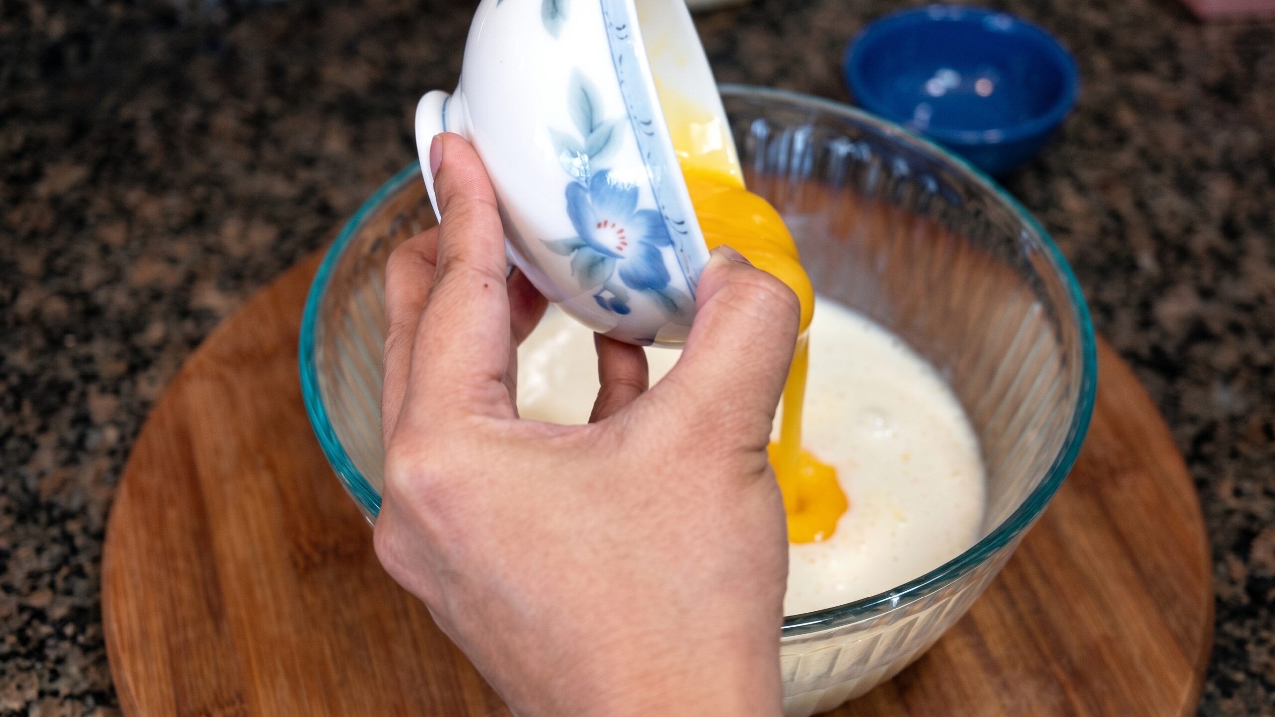 Smooth Alphonso mango pulp being added to the creamy custard mixture