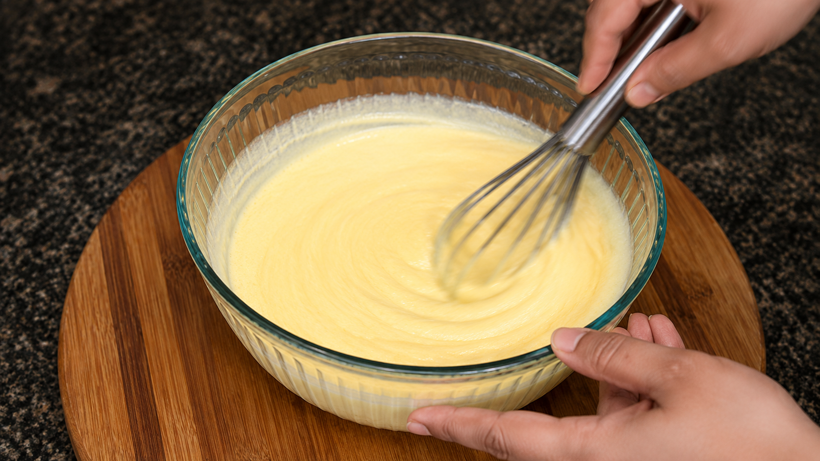 Mango custard mixture being whisked with condensed milk and a pinch of salt