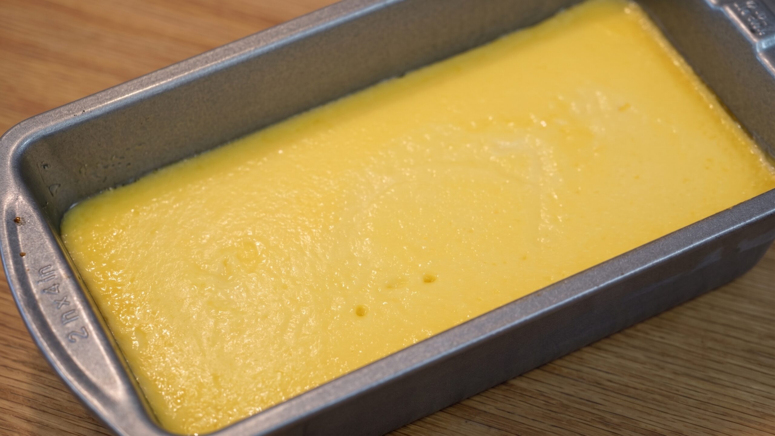 Knife gently loosening the edges of chilled mango caramel custard