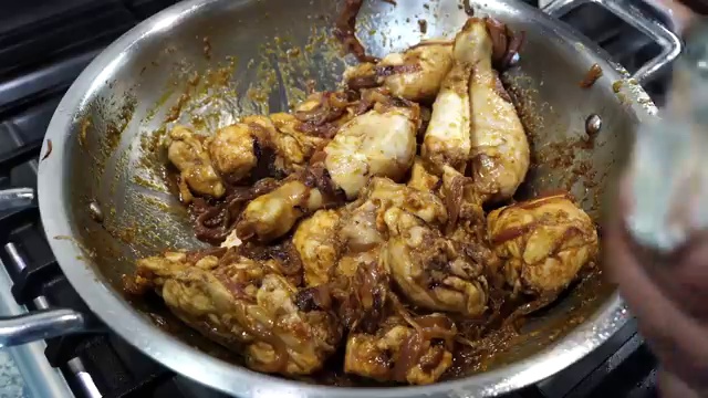 Pan uncovered showing tender cooked chicken coated in a thick, rich yogurt gravy