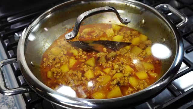 Chicken keema curry simmering gently with tender potato cubes on low heat