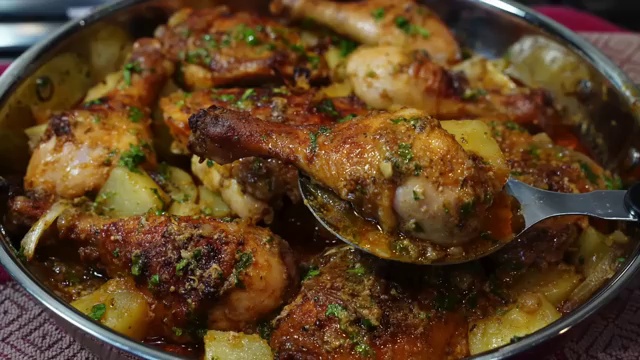 Raw bone-in skin-on chicken thighs and drumsticks placed in a large glass marinating bowl