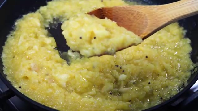 Chopped pineapple cooking with mustard seeds in a pan