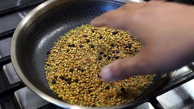 Freshly ground coarse mango pickle masala powder displaying distinct spice flecks
