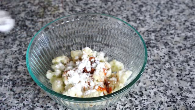 Battered cauliflower florets carefully dropped into hot oil in the wok