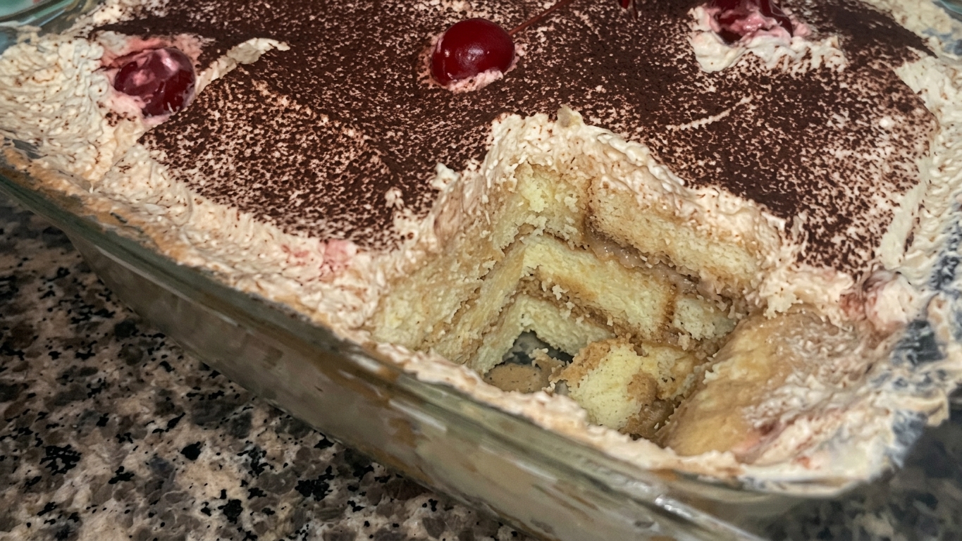 Cocoa powder being lightly dusted over the whipped cream topping