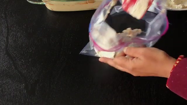 Coffee custard being spooned generously over the first layer of plain cake