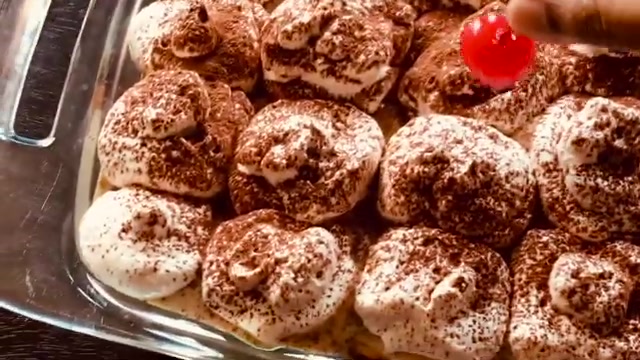 Coffee whipped cream being piped over the top of the assembled trifle using a simple zip-top bag