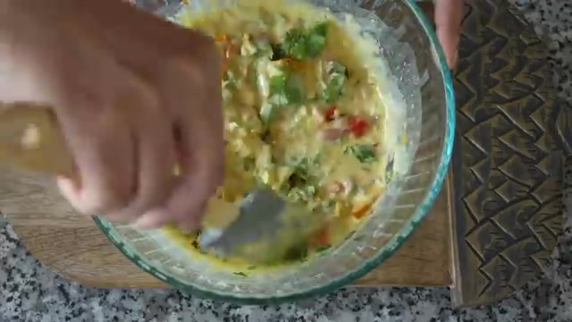 Colorful chopped vegetables and coriander mixed into the smooth besan batter