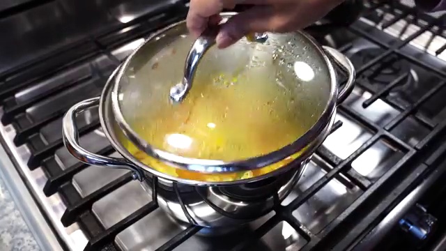 Cooked red lentils with whole green chilies ready to be removed for mild flavor