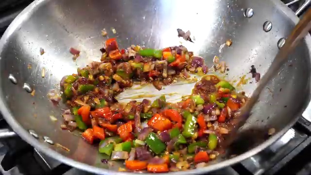 Cooked rice and chopped spring onion greens added to the cauliflower mixture in the wok