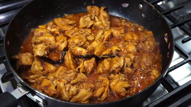Covered skillet simmering on low heat allowing chicken to cook through in its juices
