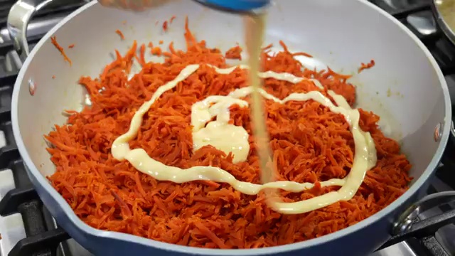 Carrot halwa covered with a lid to simmer gently over low heat