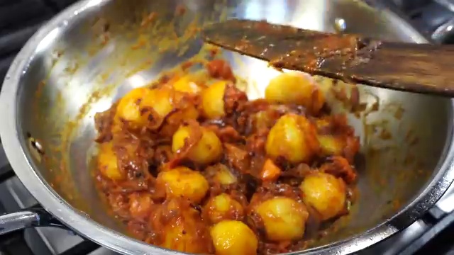 Skillet covered with a lid to simmer the baby potato curry until fork-tender