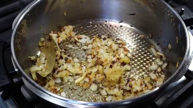 Diced tomatoes added to the spiced onion and ginger mixture in the pressure cooker
